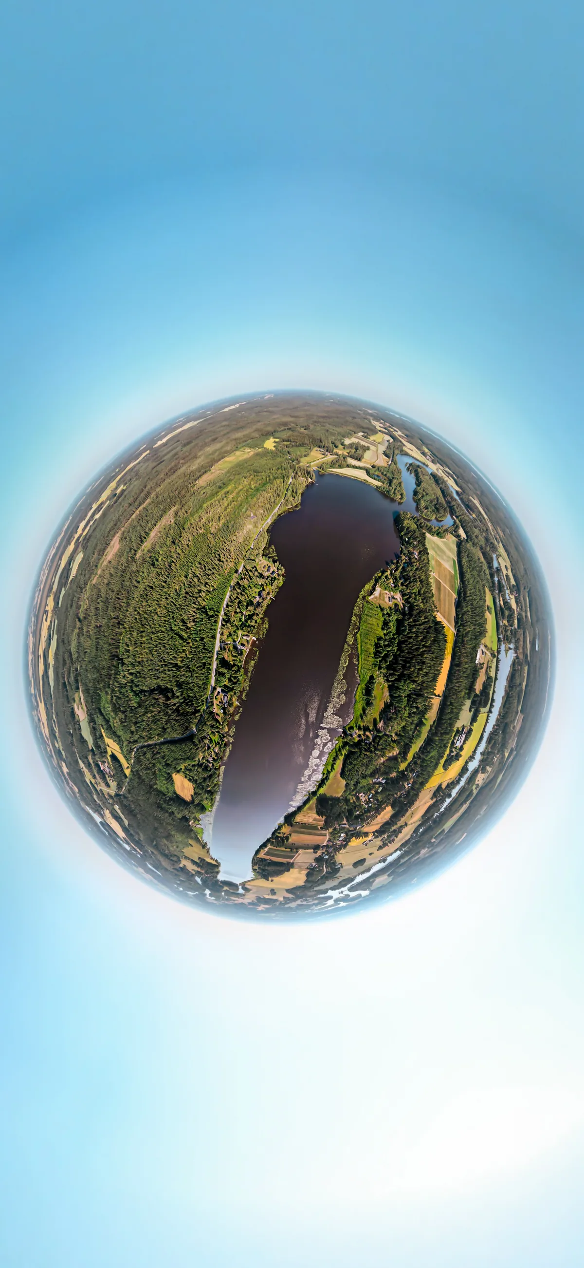 Pikkuplaneetta metsäsaaresta järvellä pilvisellä taivaalla