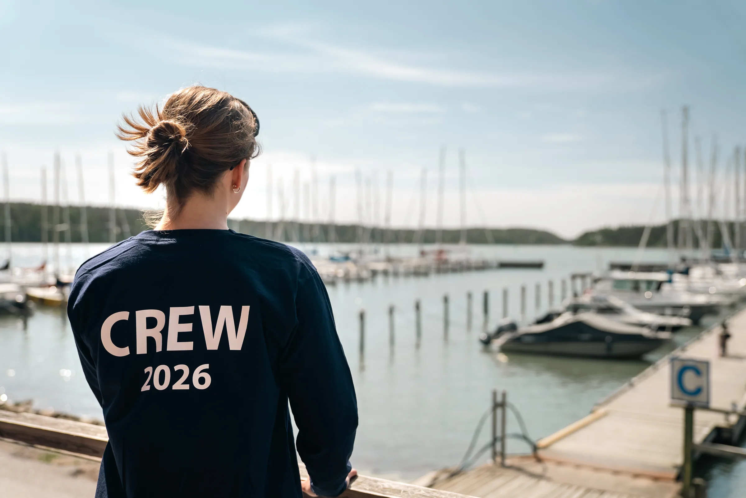 Purjehdusseuran miehistön jäsen satamassa CREW-paidassa